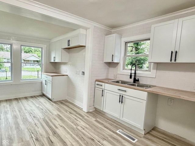 3712 S Kealing Ave S, Indianapolis, IN 46237 - kitchen with light wood-style floors, healthy amount of natural light, crown molding, and white cabinets