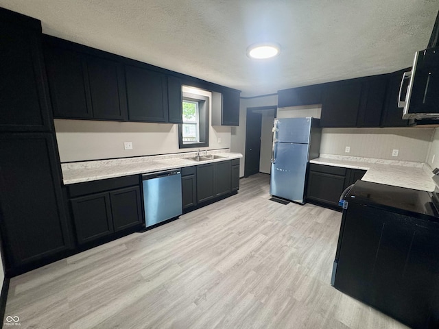 1013 E Pike St, Crawfordsville, IN 47933 - kitchen featuring appliances with stainless steel finishes, light wood-style flooring, light countertops, and a textured ceiling