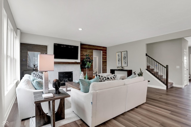 5343 Pelion Pl, Mccordsville, IN 46055 - living area featuring an accent wall, stairway, a tiled fireplace, light wood-type flooring, and recessed lighting