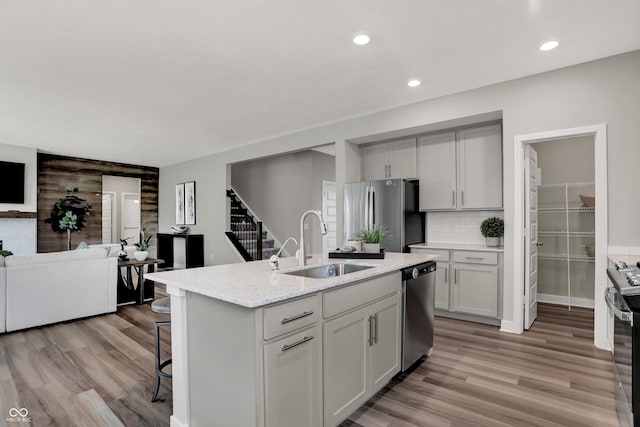 5343 Pelion Pl, Mccordsville, IN 46055 - kitchen featuring stainless steel appliances, a breakfast bar area, open floor plan, light wood-style floors, and an island with sink