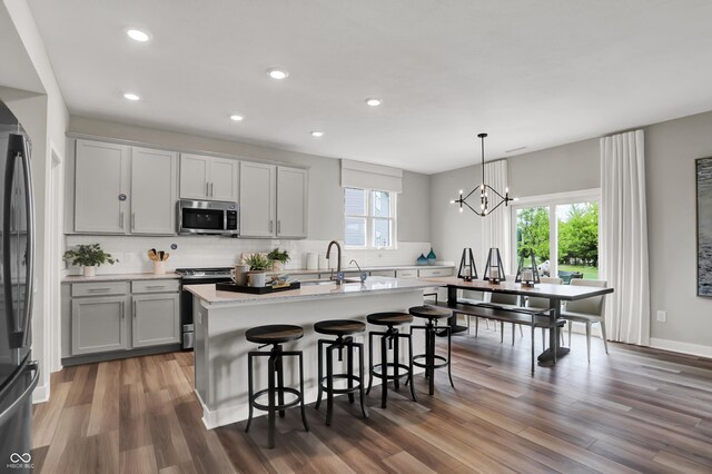 5343 Pelion Pl, Mccordsville, IN 46055 - kitchen featuring appliances with stainless steel finishes, a breakfast bar area, tasteful backsplash, healthy amount of natural light, and recessed lighting