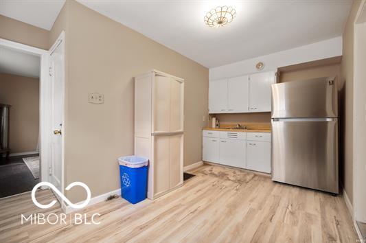 2410 S Ebright St, Muncie, IN 47302 - kitchen featuring freestanding refrigerator, light wood-style flooring, white cabinets, and light countertops
