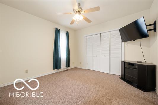 2410 S Ebright St, Muncie, IN 47302 - unfurnished bedroom with carpet flooring, a closet, and a ceiling fan