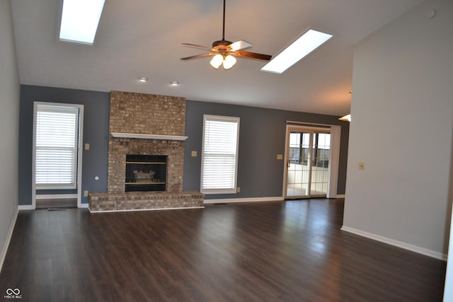 112 Marble Arch Way, Lafayette, IN 47905 - unfurnished living room featuring vaulted ceiling, a skylight, dark wood-style flooring, a ceiling fan, and a fireplace