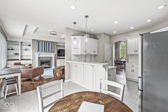2920 Bloomsbury S, Greenwood, IN 46143 - kitchen with freestanding refrigerator, a peninsula, arched walkways, light countertops, and recessed lighting