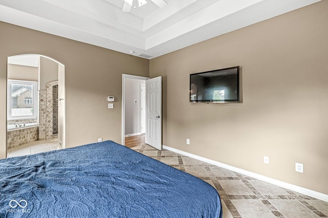 2920 Bloomsbury S, Greenwood, IN 46143 - bedroom with arched walkways, connected bathroom, ceiling fan, a raised ceiling, and tile patterned floors