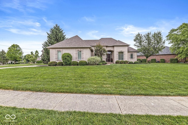 2920 Bloomsbury S, Greenwood, IN 46143 - french country home featuring a front lawn, a shingled roof, and brick siding