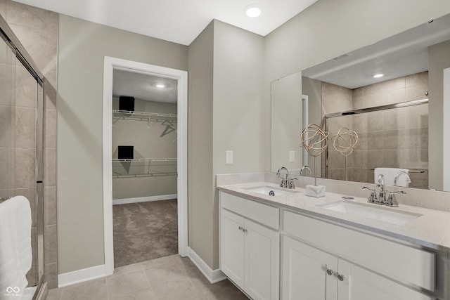 19838 Moorpark Lndg, Noblesville, IN 46062 - bathroom featuring a stall shower, a walk in closet, double vanity, and tile patterned flooring