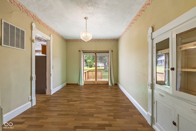 206 E Franklin St, Roachdale, IN 46172 - unfurnished dining area featuring dark wood-style flooring, a chandelier, and a textured ceiling