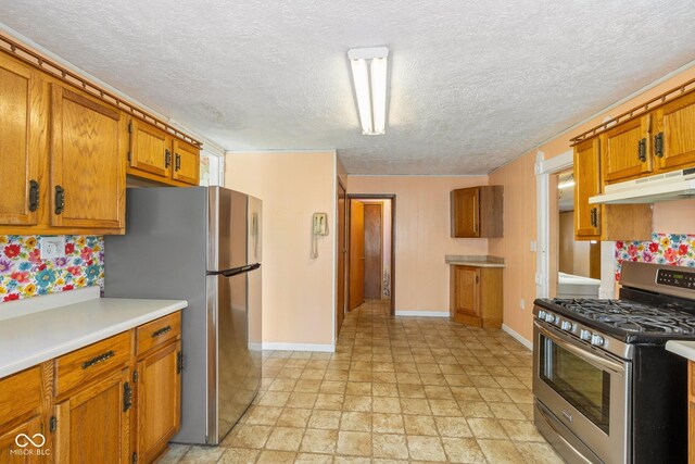 206 E Franklin St, Roachdale, IN 46172 - kitchen featuring stainless steel appliances, under cabinet range hood, brown cabinets, light countertops, and a textured ceiling