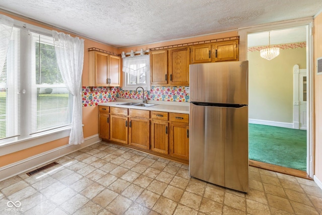 206 E Franklin St, Roachdale, IN 46172 - kitchen with freestanding refrigerator, light countertops, a chandelier, brown cabinets, and a textured ceiling