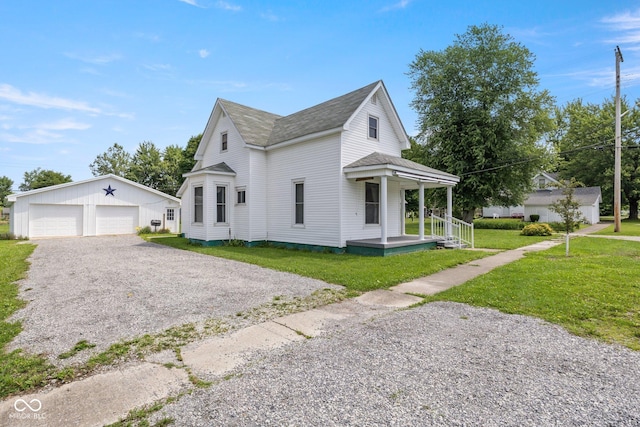 206 E Franklin St, Roachdale, IN 46172 - view of property exterior with covered porch, an outdoor structure, a lawn, a detached garage, and a shingled roof