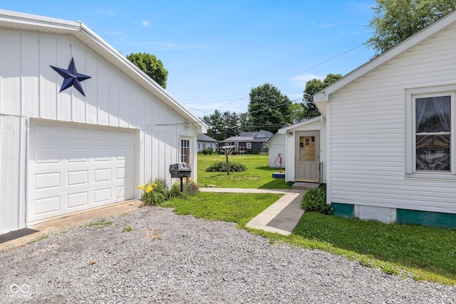 206 E Franklin St, Roachdale, IN 46172 - view of green lawn with gravel driveway and a garage
