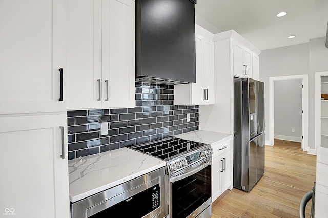 2008 Yandes St, Indianapolis, IN 46202 - kitchen featuring stainless steel appliances, range hood, light wood-style flooring, light stone countertops, and tasteful backsplash