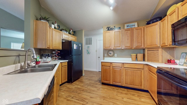6816 Minnow Dr, Indianapolis, IN 46237 - kitchen featuring black appliances, a textured ceiling, light wood finished floors, light countertops, and light brown cabinets