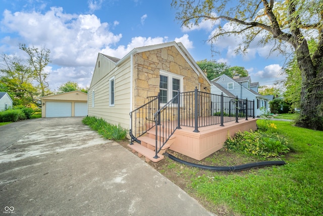 171 Nursery Rd, Anderson, IN 46012 - view of front of property featuring a detached garage, an outbuilding, stone siding, and a front yard