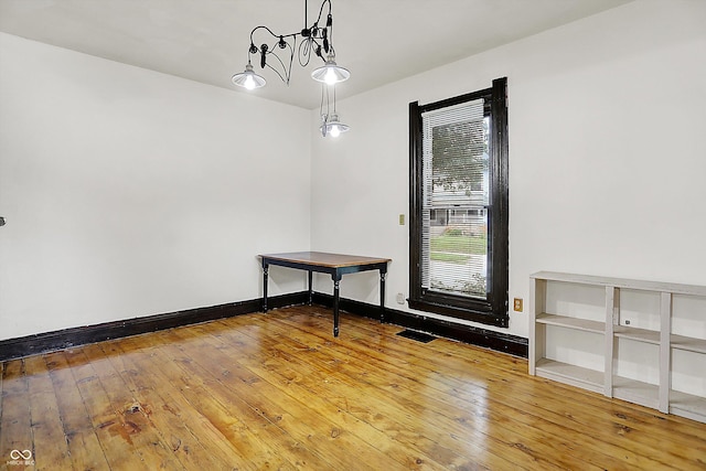 115 Simpson St, Crawfordsville, IN 47933 - empty room featuring hardwood / wood-style flooring and a chandelier