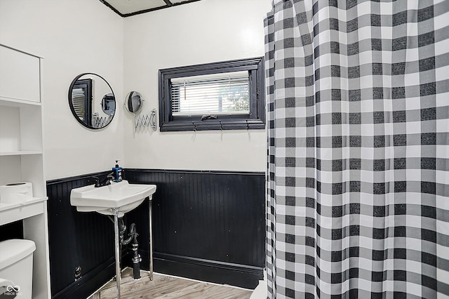 115 Simpson St, Crawfordsville, IN 47933 - bathroom featuring wood finished floors, wainscoting, and a shower with shower curtain