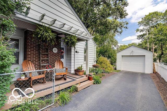 5363 Primrose Ave, Indianapolis, IN 46220 - deck featuring an outdoor structure, a garage, and asphalt driveway