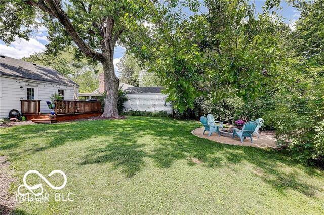 5363 Primrose Ave, Indianapolis, IN 46220 - view of green lawn featuring a wooden deck, an outdoor fire pit, and a patio area