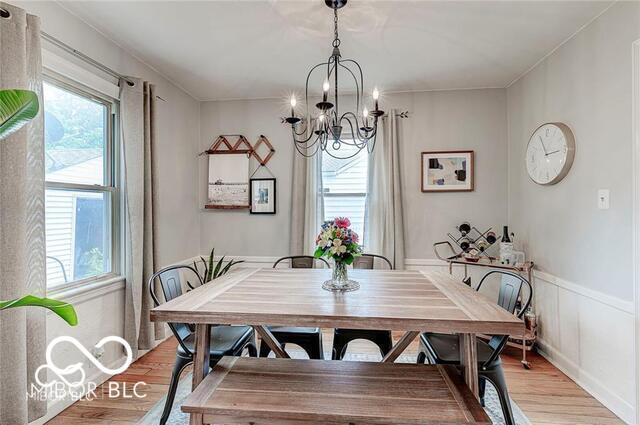 5363 Primrose Ave, Indianapolis, IN 46220 - dining area with a chandelier, light wood finished floors, and a wainscoted wall