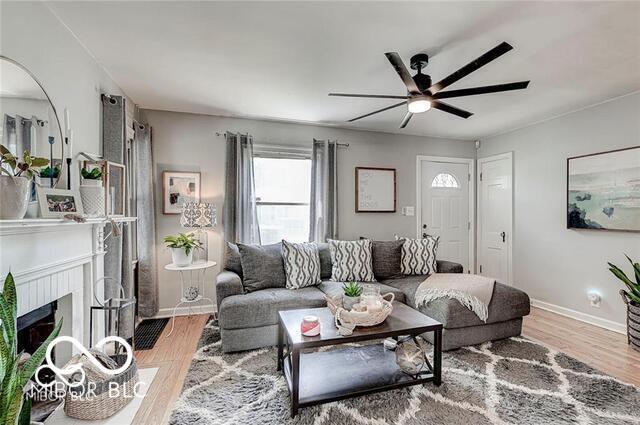 5363 Primrose Ave, Indianapolis, IN 46220 - living area with a ceiling fan, wood finished floors, and a fireplace