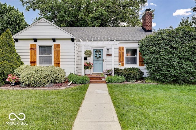5363 Primrose Ave, Indianapolis, IN 46220 - view of front of house with a front lawn, a shingled roof, and a chimney