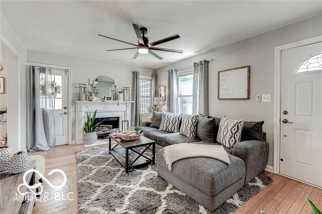 5363 Primrose Ave, Indianapolis, IN 46220 - living area with a ceiling fan, light wood finished floors, and a fireplace with flush hearth
