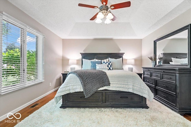 770 Viewpoint Dr, Plainfield, IN 46168 - bedroom featuring a textured ceiling, wood finished floors, a ceiling fan, and a raised ceiling