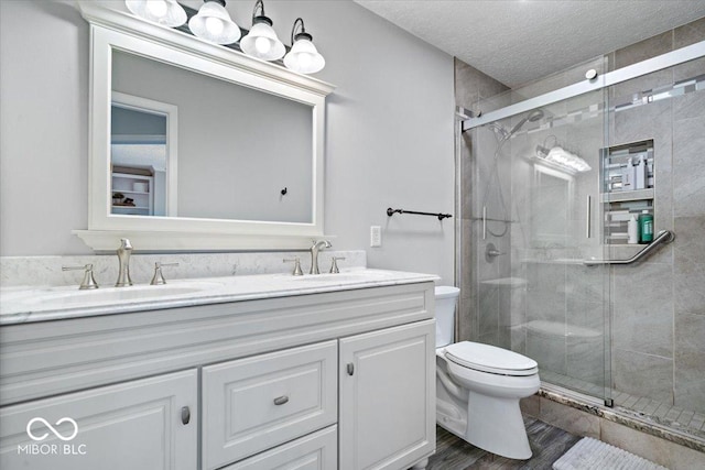 770 Viewpoint Dr, Plainfield, IN 46168 - full bathroom with double vanity, a stall shower, a textured ceiling, and wood finished floors