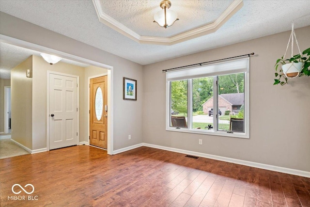 770 Viewpoint Dr, Plainfield, IN 46168 - foyer featuring hardwood / wood-style floors, a tray ceiling, a textured ceiling, and ornamental molding
