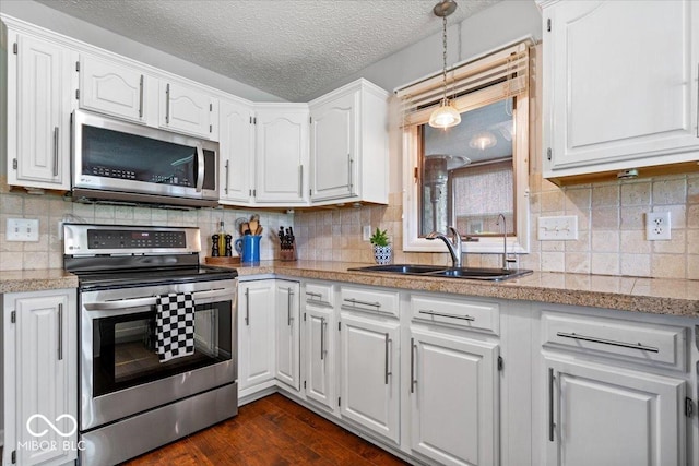 770 Viewpoint Dr, Plainfield, IN 46168 - kitchen with stainless steel appliances, white cabinets, dark wood-type flooring, decorative light fixtures, and a textured ceiling