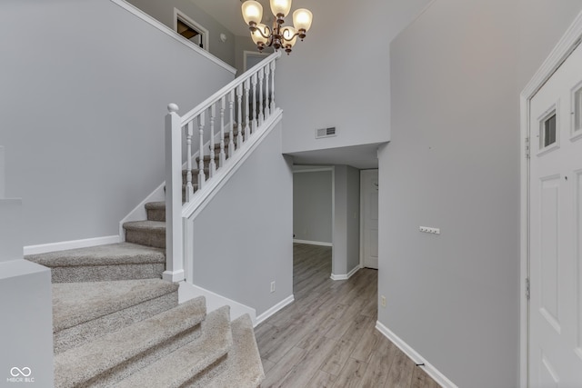 7914 Willow Wind Cir, Indianapolis, IN 46239 - stairway featuring a chandelier, wood finished floors, and a high ceiling