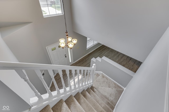 7914 Willow Wind Cir, Indianapolis, IN 46239 - staircase featuring healthy amount of natural light, a towering ceiling, and wood finished floors