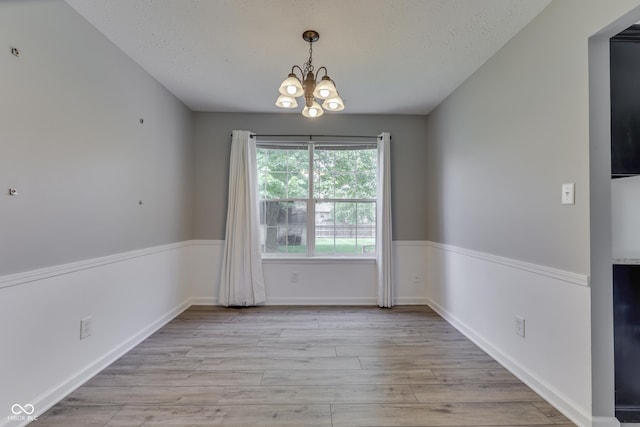 7914 Willow Wind Cir, Indianapolis, IN 46239 - spare room featuring a chandelier, light wood-type flooring, and a textured ceiling