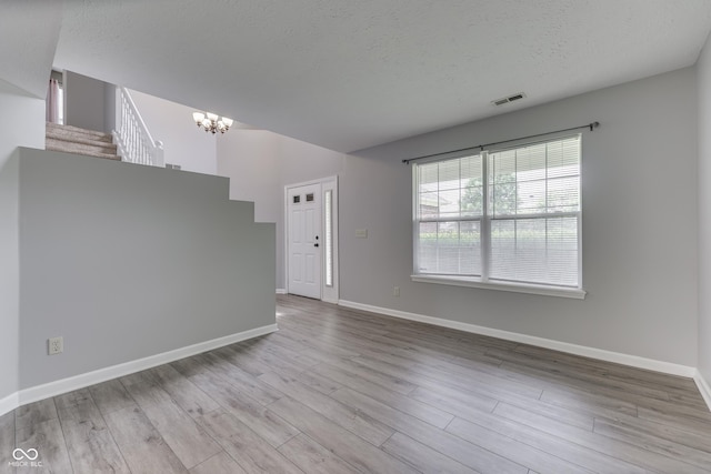 7914 Willow Wind Cir, Indianapolis, IN 46239 - spare room featuring a chandelier, wood finished floors, stairway, and a textured ceiling