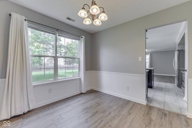 7914 Willow Wind Cir, Indianapolis, IN 46239 - spare room with a chandelier and light wood-style floors