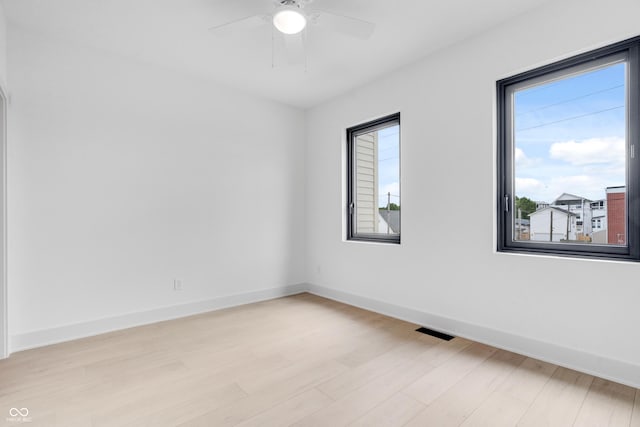 1100 English Ave, Indianapolis, IN 46203 - spare room featuring healthy amount of natural light, light wood-style flooring, and a ceiling fan