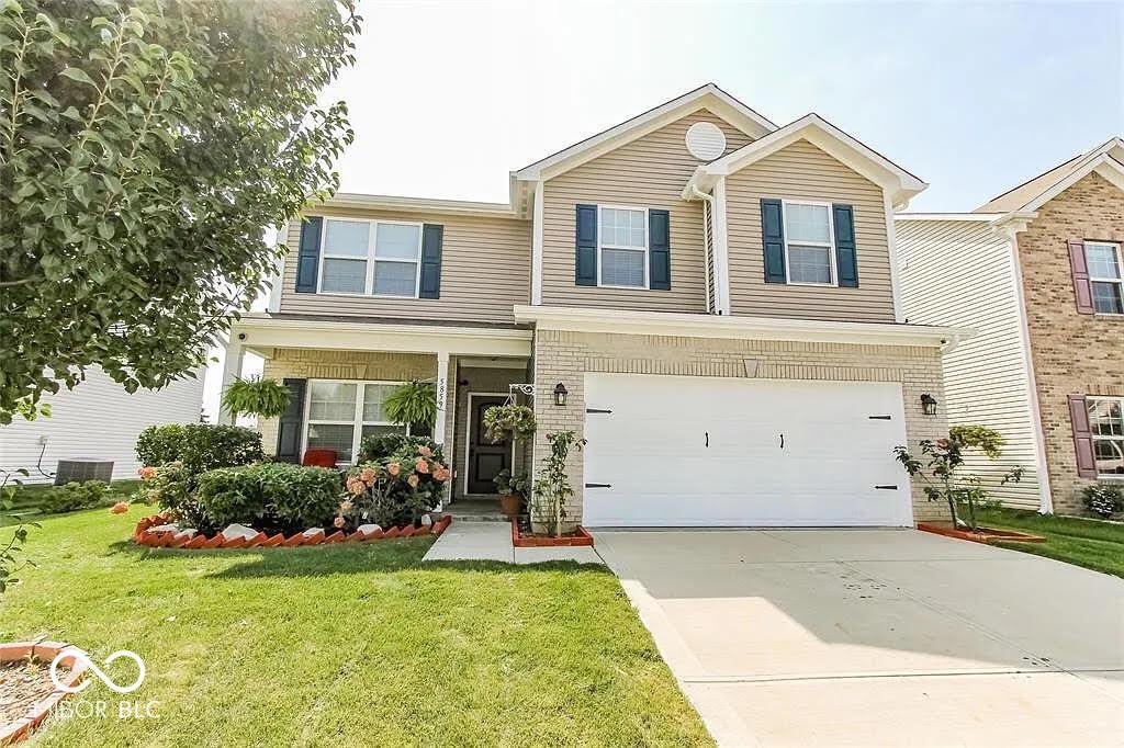 5859 Edelle Dr, Indianapolis, IN 46237 - traditional-style home featuring a front lawn, an attached garage, driveway, and brick siding