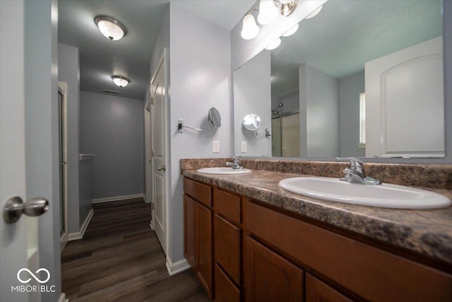 5859 Edelle Dr, Indianapolis, IN 46237 - full bath featuring wood finished floors, double vanity, and a shower with shower door