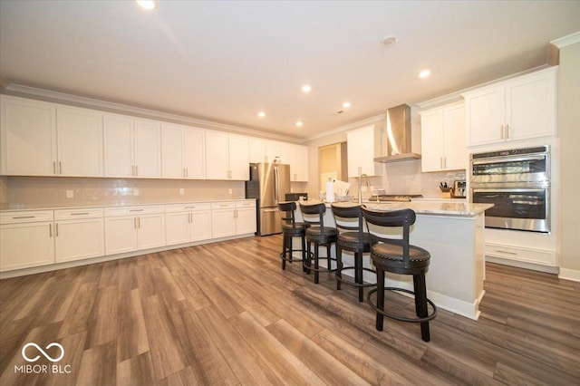 3609 Merchmont Rd, Bargersville, IN 46106 - kitchen with appliances with stainless steel finishes, wall chimney range hood, wood finished floors, white cabinets, and ornamental molding