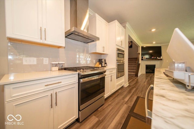 3609 Merchmont Rd, Bargersville, IN 46106 - kitchen featuring appliances with stainless steel finishes, wall chimney range hood, white cabinetry, light countertops, and decorative backsplash