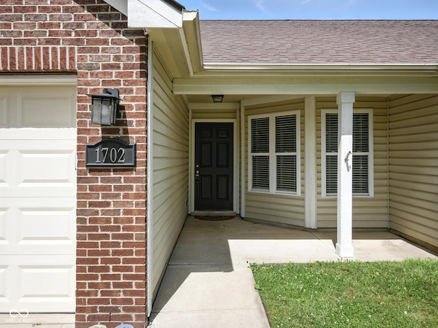 1702 Juniper Ln, Greenwood, IN 46143 - view of exterior entry with brick siding and a shingled roof