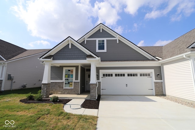 10602 Maidenhair Dr, Indianapolis, IN 46239 - craftsman-style house featuring stone siding, covered porch, driveway, a garage, and a front lawn
