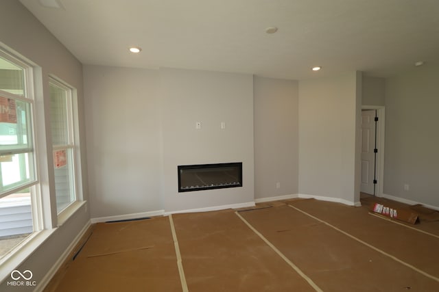 10602 Maidenhair Dr, Indianapolis, IN 46239 - unfurnished living room featuring a glass covered fireplace and recessed lighting