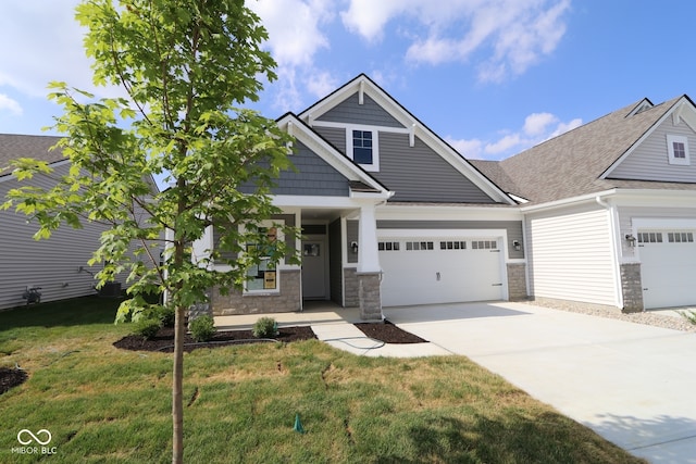 10602 Maidenhair Dr, Indianapolis, IN 46239 - craftsman house featuring a front lawn, concrete driveway, covered porch, a garage, and stone siding
