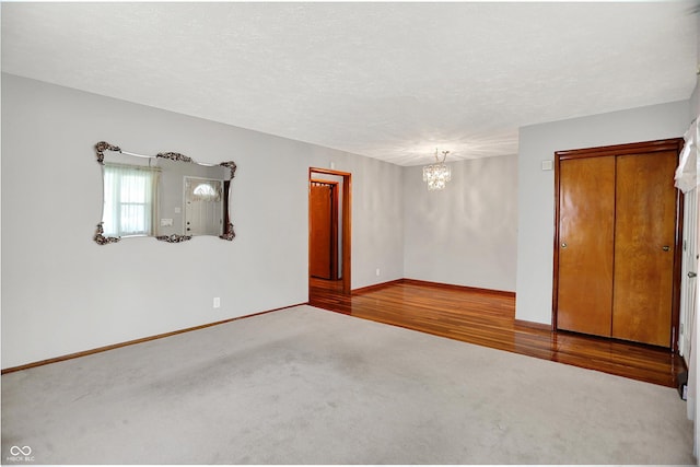 3322 N Riley Ave N, Indianapolis, IN 46218 - carpeted empty room with a chandelier and a textured ceiling
