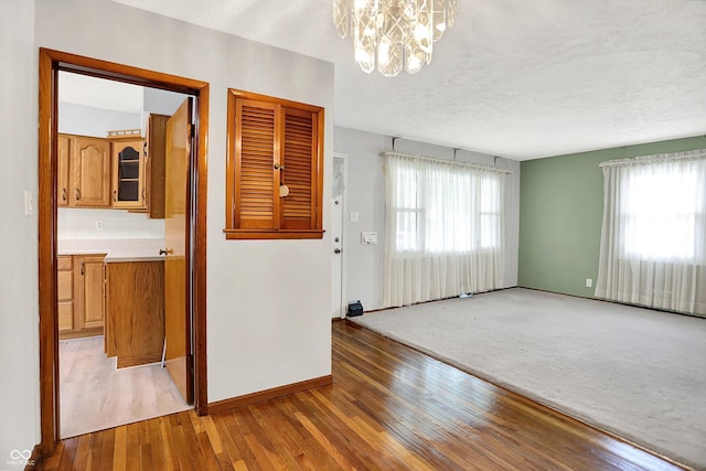 3322 N Riley Ave N, Indianapolis, IN 46218 - unfurnished room with plenty of natural light, a chandelier, light wood-type flooring, and a textured ceiling