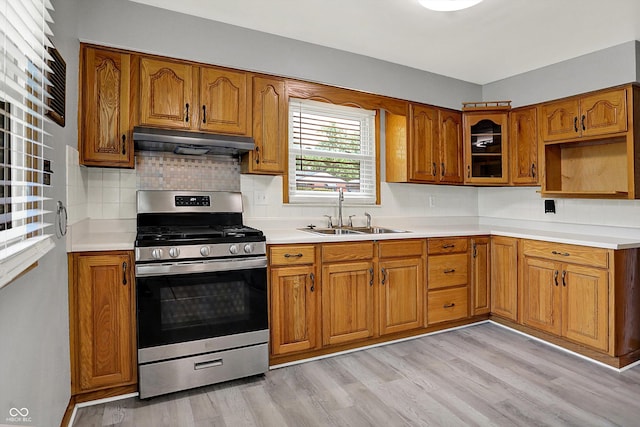 3322 N Riley Ave N, Indianapolis, IN 46218 - kitchen with gas stove, under cabinet range hood, and brown cabinets