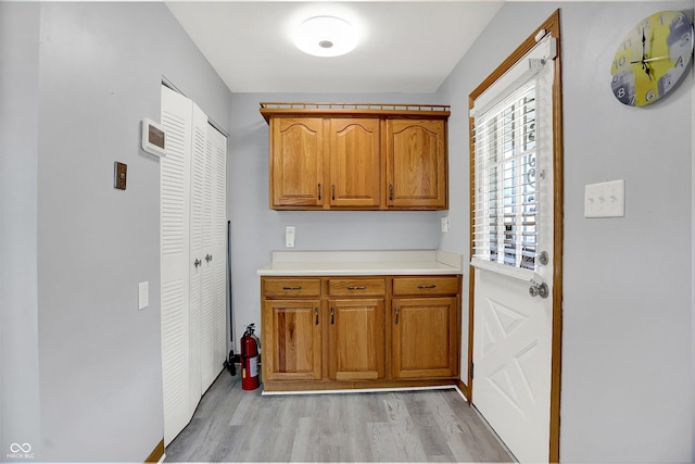 3322 N Riley Ave N, Indianapolis, IN 46218 - kitchen featuring light wood finished floors, brown cabinetry, and light countertops